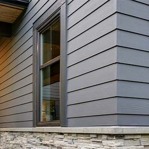 House with blue vinyl and grey stone siding